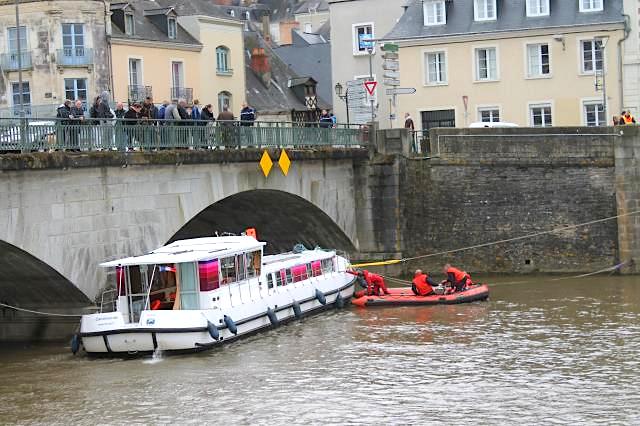 Pénichette bloquée par le courant contre le Vieux-Pont de Château-Gontier (Photo J.Hutin - Ouest-France)